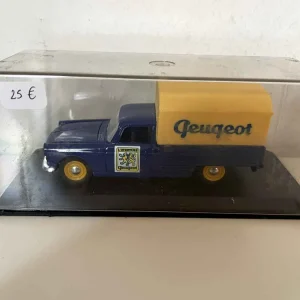 Peugeot 404 bâchée bleue et jaune avec le logo "l'aventure Peugeot" sur les portières (Eligor)