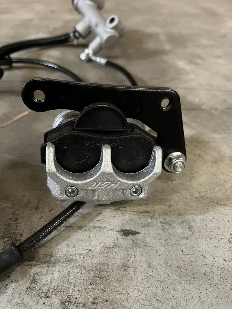Système de freinage adapté pour balayeuse autoportée & Balayeuse avec cabine